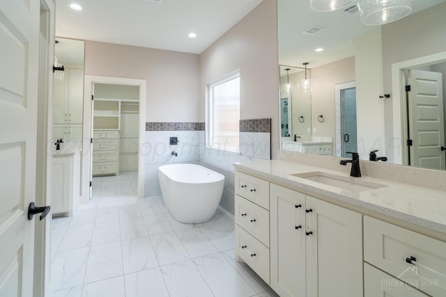 1207 Herring Ranch Rd, Amarillo, TX 79124 - full bathroom featuring a spacious closet, vanity, a soaking tub, marble finish flooring, and tile walls