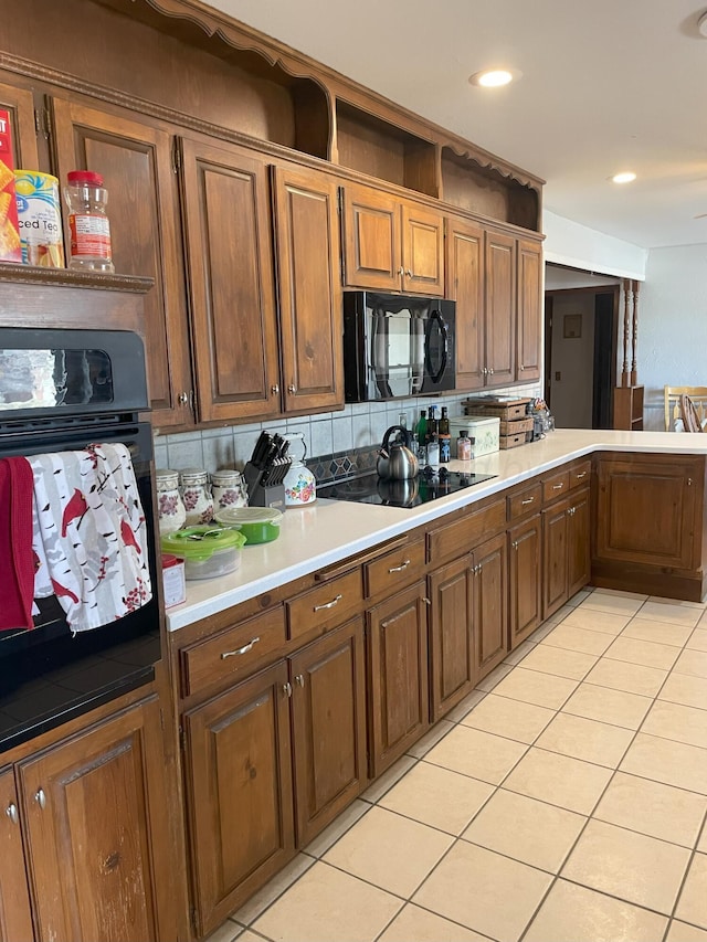 kitchen with light tile patterned floors, backsplash, and black appliances