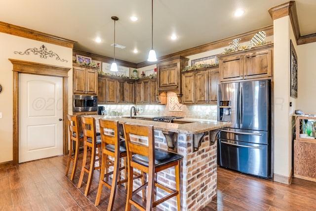 12 William Ln, Canyon, TX 79015 - kitchen featuring stainless steel appliances, light stone counters, dark wood-style floors, backsplash, and a kitchen bar