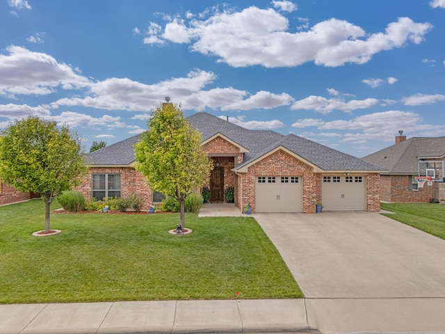 12 William Ln, Canyon, TX 79015 - view of front of home with an attached garage, driveway, a front yard, brick siding, and roof with shingles