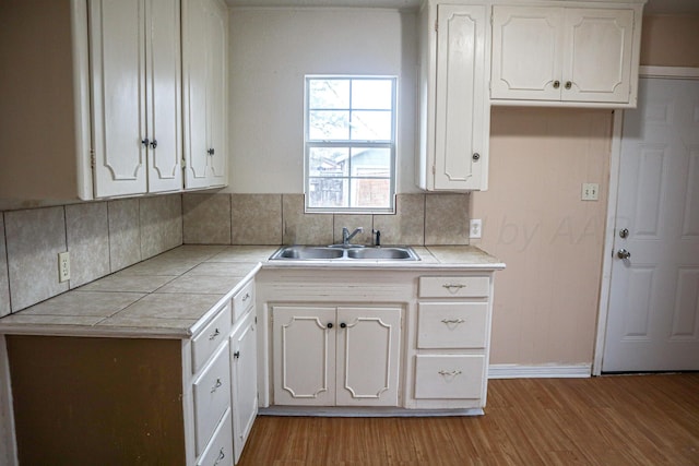 kitchen featuring white cabinets, light hardwood / wood-style floors, and sink