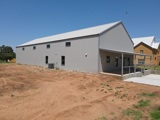 rear view of property with central AC