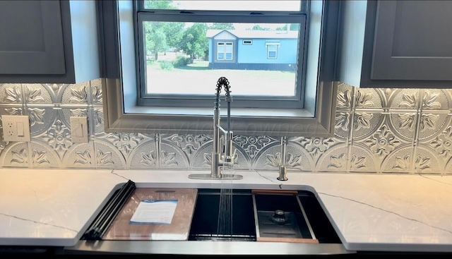 details featuring light stone countertops and decorative backsplash
