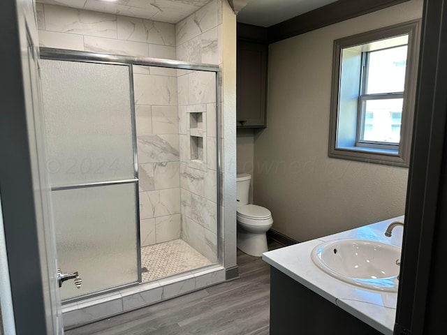 bathroom featuring hardwood / wood-style flooring, vanity, toilet, and walk in shower
