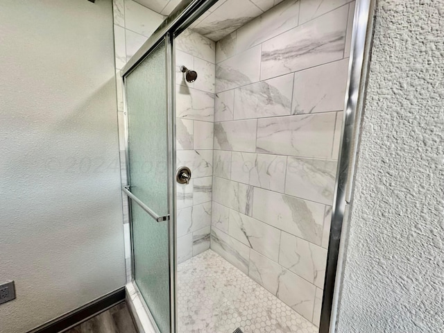 bathroom with hardwood / wood-style floors and a shower with shower door