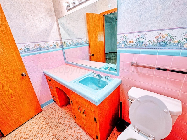 1301 S Fordham St, Perryton, TX 79070 - bathroom featuring tile walls, vanity, wainscoting, and wallpapered walls