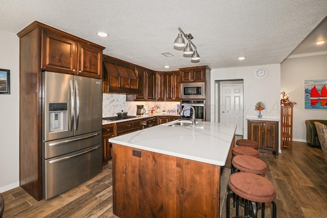 3001 Bismarck Ave, Amarillo, TX 79118 - kitchen featuring appliances with stainless steel finishes, premium range hood, wood finish floors, light countertops, and a textured ceiling