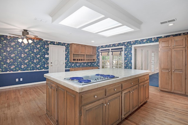 2614 Parker St, Amarillo, TX 79109 - kitchen featuring wallpapered walls, tile countertops, crown molding, a ceiling fan, and light wood-style floors