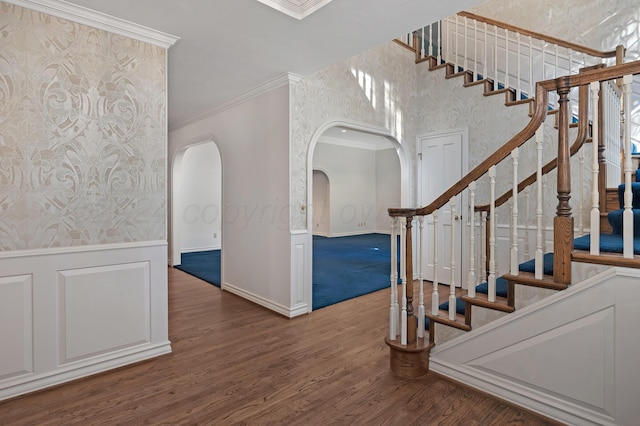 2614 Parker St, Amarillo, TX 79109 - stairs featuring arched walkways, crown molding, wood finished floors, a wainscoted wall, and baseboards