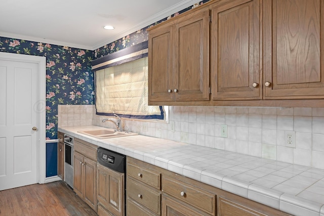 2614 Parker St, Amarillo, TX 79109 - kitchen featuring wallpapered walls, a sink, dishwasher, ornamental molding, and dark wood-style floors