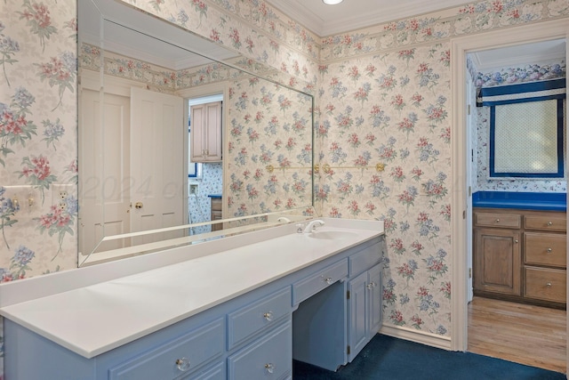 2614 Parker St, Amarillo, TX 79109 - bathroom featuring wallpapered walls, vanity, baseboards, crown molding, and wood finished floors