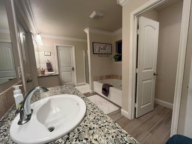 bathroom featuring a shower stall, a garden tub, visible vents, ornamental molding, and wood finished floors