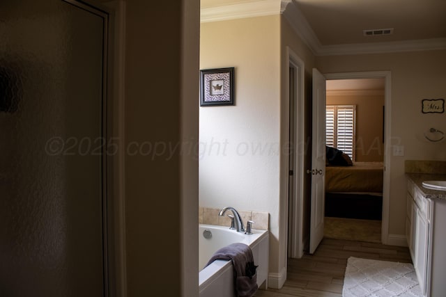 bathroom featuring wood finished floors, ornamental molding, a bath, ensuite bathroom, and visible vents