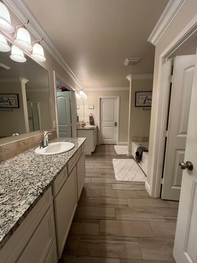 bathroom with wood finished floors, ornamental molding, vanity, visible vents, and a shower