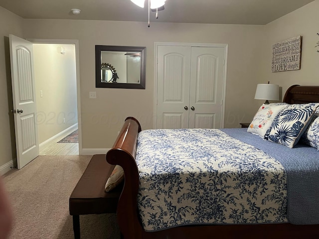 carpeted bedroom with a closet and baseboards