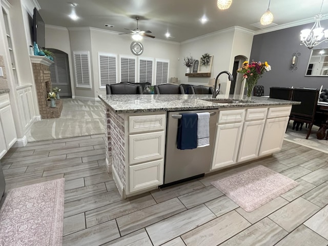 kitchen featuring a sink, stainless steel dishwasher, wood finish floors, open floor plan, and ceiling fan with notable chandelier