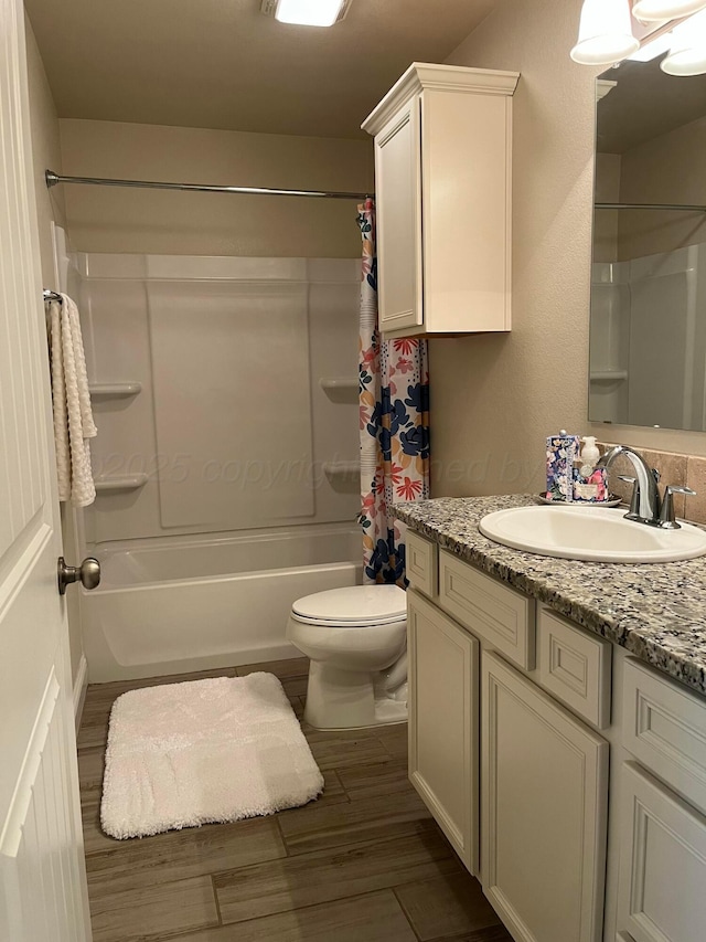 full bathroom with shower / bath combo, wood finished floors, toilet, and vanity