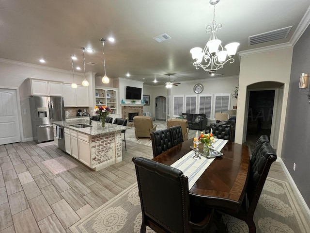 dining area with visible vents, ornamental molding, and ceiling fan with notable chandelier