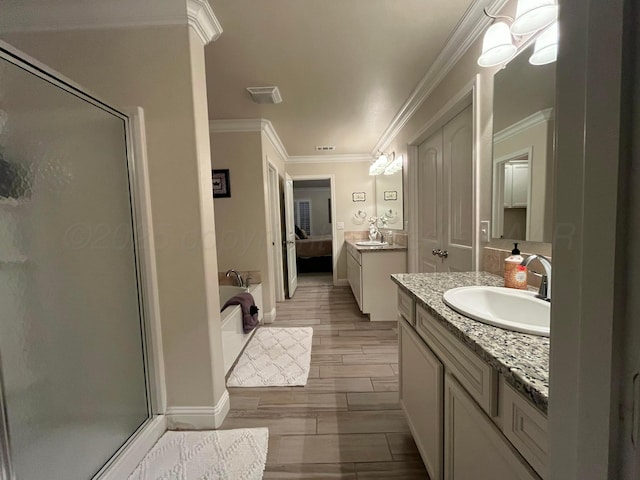 bathroom featuring a sink, crown molding, a stall shower, two vanities, and visible vents