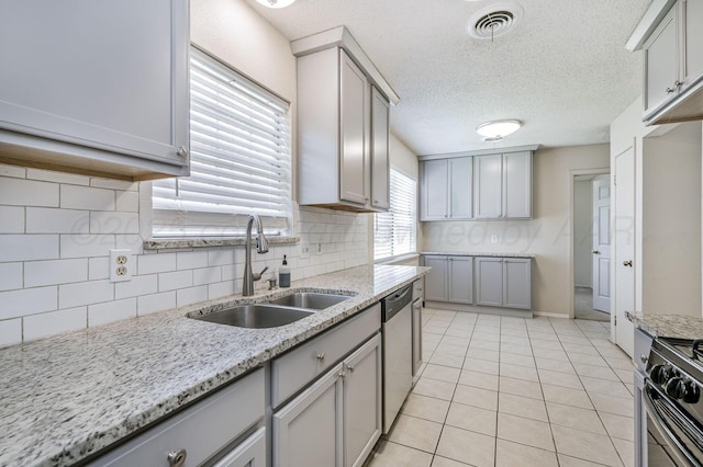 1736 Jennifer St, Amarillo, TX 79107 - kitchen with gray cabinets, backsplash, dishwasher, light tile patterned flooring, and stove