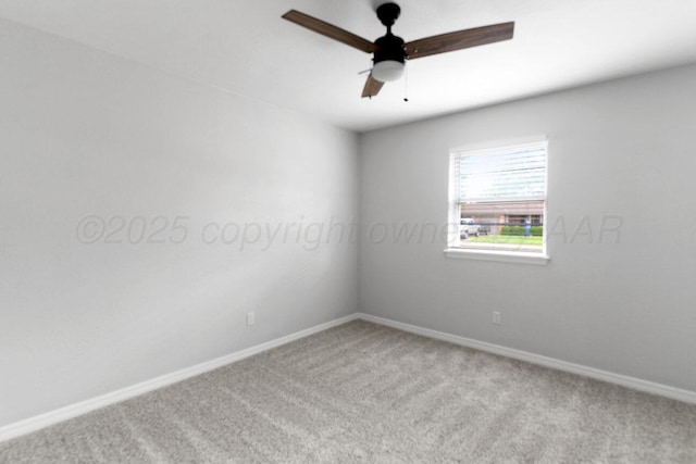 carpeted spare room with a ceiling fan and baseboards