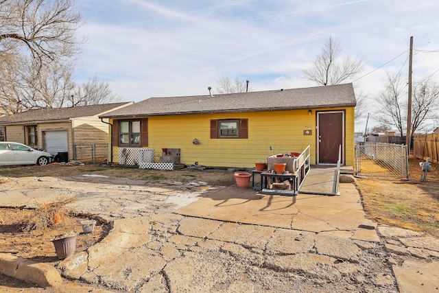 back of property with a garage and a patio area