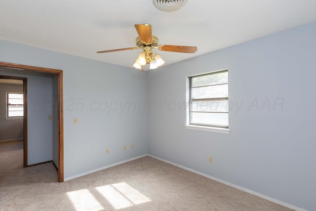unfurnished room with light colored carpet, baseboards, a healthy amount of sunlight, and visible vents