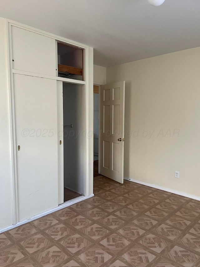 unfurnished bedroom featuring a closet and baseboards