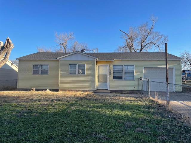 view of front facade with a garage, concrete driveway, roof with shingles, fence, and a front yard