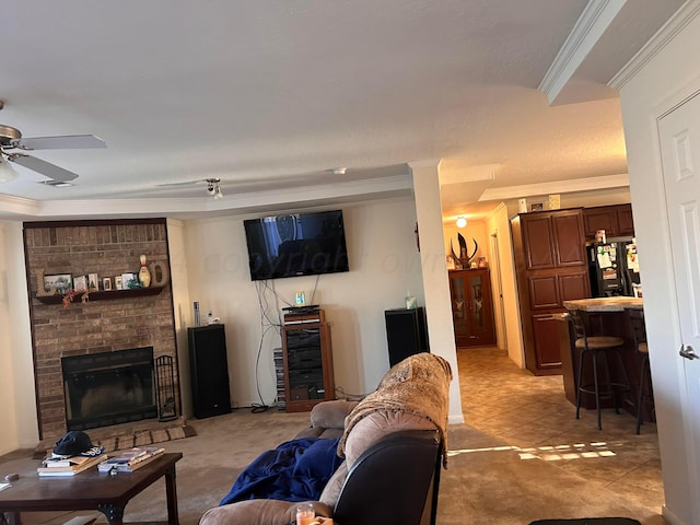 living room featuring a brick fireplace, a textured ceiling, ceiling fan, and crown molding