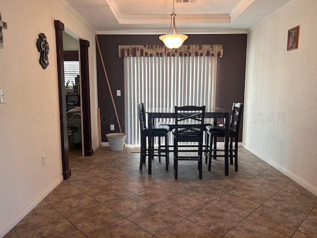 dining area featuring ornamental molding and a tray ceiling