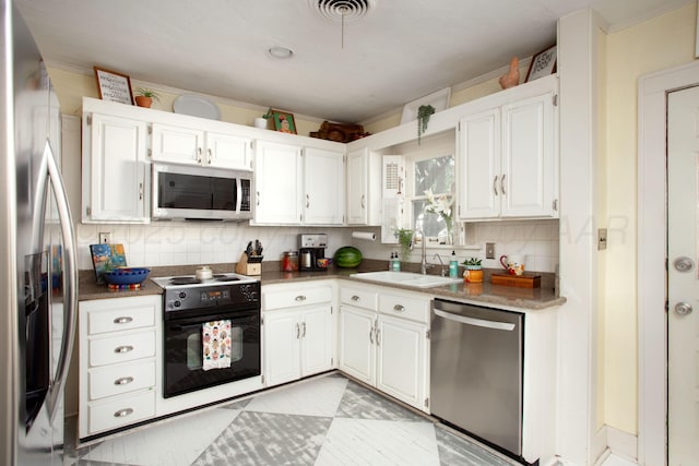 2402 S Ong St, Amarillo, TX 79109 - kitchen featuring stainless steel appliances, backsplash, white cabinets, ornamental molding, and light countertops
