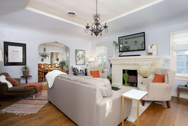 2402 S Ong St, Amarillo, TX 79109 - living room featuring a chandelier, arched walkways, wood finished floors, and a brick fireplace