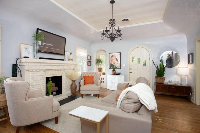 2402 S Ong St, Amarillo, TX 79109 - living area with a chandelier, a tray ceiling, wood finished floors, and a brick fireplace