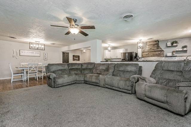 1607 N Mary-Ellen St, Pampa, TX 79065 - living area featuring a textured ceiling, a ceiling fan, a chandelier, and wood finished floors