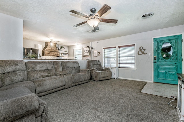 1607 N Mary-Ellen St, Pampa, TX 79065 - carpeted living area with a ceiling fan, baseboards, tile patterned floors, and a textured ceiling