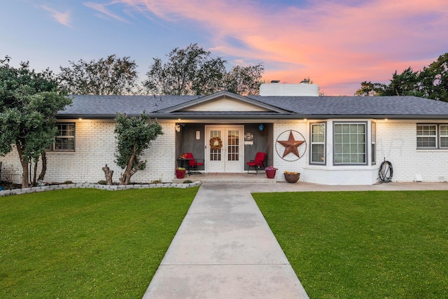 single story home with a patio area, a lawn, and french doors