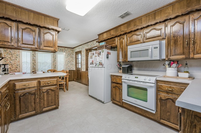 314 Fir St, Hereford, TX 79045 - kitchen with white appliances, wallpapered walls, wainscoting, light countertops, and a textured ceiling