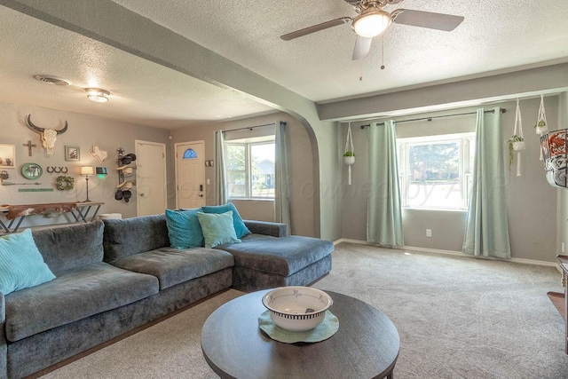 215 Abilene St, Borger, TX 79007 - living room with a textured ceiling, carpet flooring, ceiling fan, and arched walkways