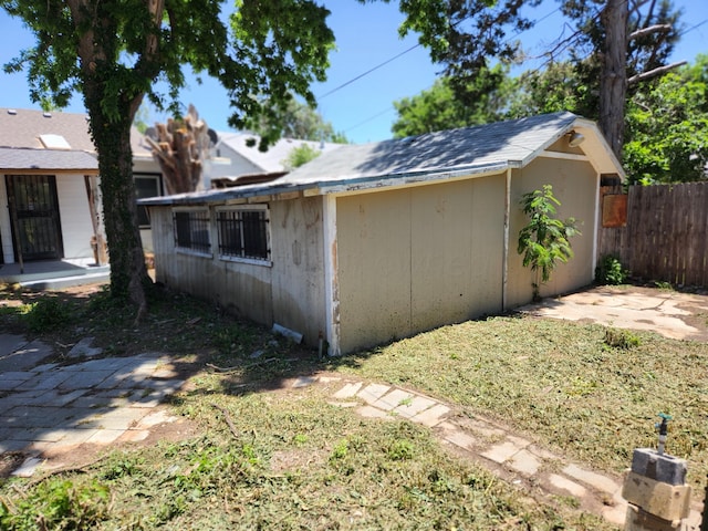 view of outdoor structure featuring fence and an outbuilding