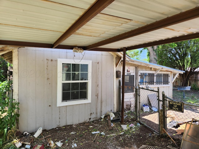 view of side of home with fence and an outbuilding