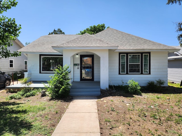 bungalow-style home with roof with shingles and covered porch