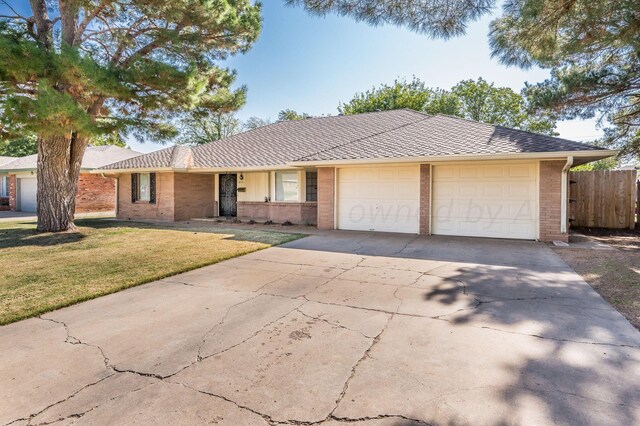 ranch-style house featuring a garage and a front lawn