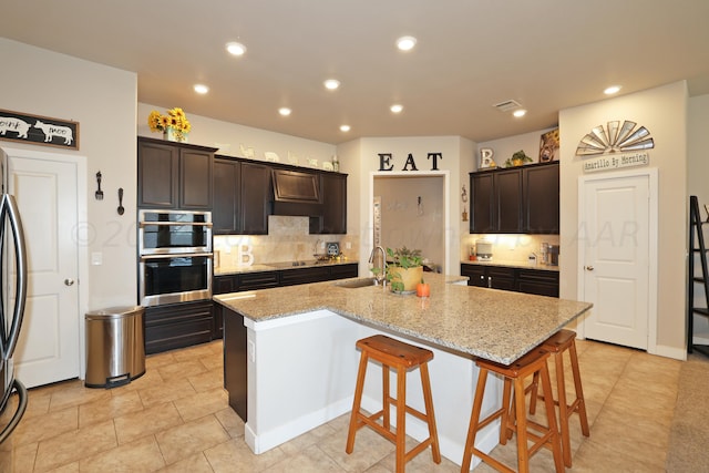 9709 Sydney Dr, Amarillo, TX 79119 - kitchen with a sink, stainless steel appliances, a kitchen island with sink, decorative backsplash, and a breakfast bar