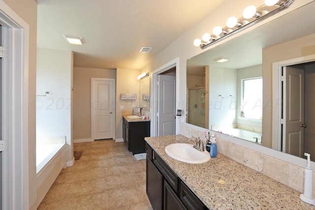 9709 Sydney Dr, Amarillo, TX 79119 - full bath featuring a stall shower, a garden tub, two vanities, and tile patterned floors