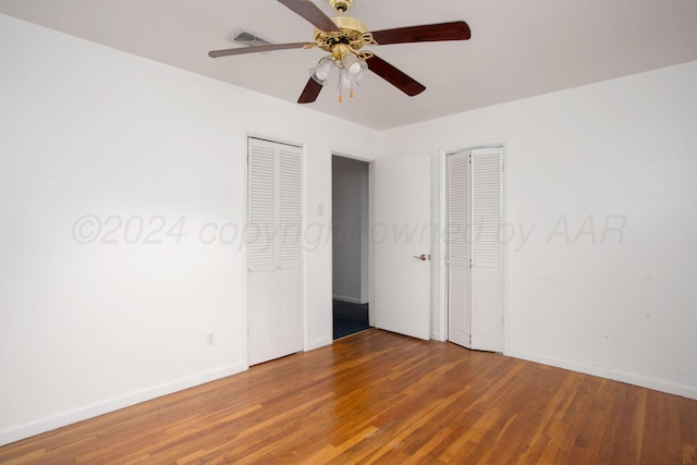 2501 S Bivins St, Amarillo, TX 79103 - unfurnished bedroom with multiple closets, wood finished floors, and a ceiling fan