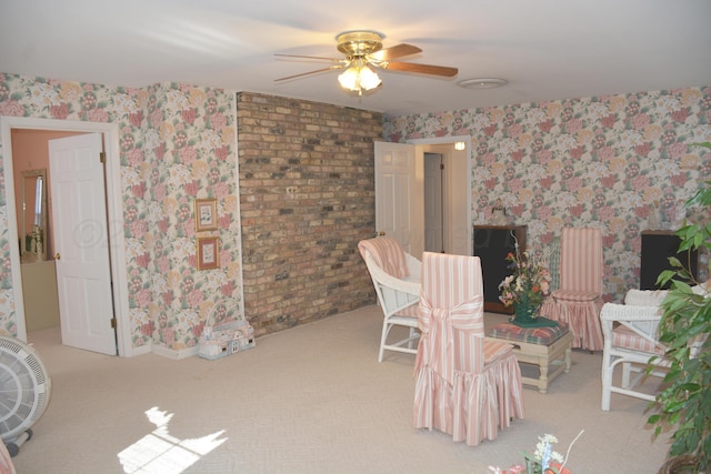 sitting room featuring a ceiling fan, light colored carpet, and wallpapered walls