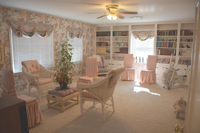 living area featuring carpet flooring, a ceiling fan, and wallpapered walls