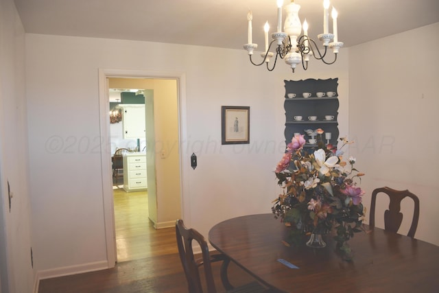 dining space with a chandelier, dark wood-style flooring, and baseboards