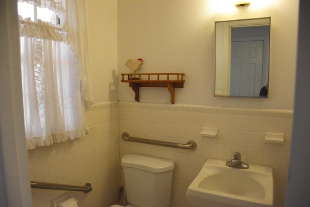 bathroom featuring wainscoting, a sink, and toilet